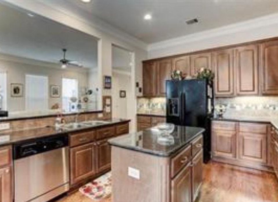 Island kitchen features granite countertops, wood cabinets, SS dishwasher, refrigerator, gas cooktop, wall oven, under cabinet lighting, & breakfast:dining area