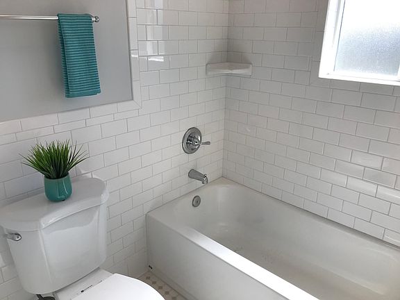 Window in bathroom, tile flooring, and curtain pole included