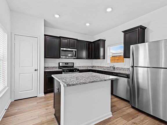 Designer kitchen with stainless appliances, granite countertops, and recessed lighting.