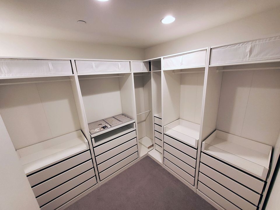 Primary bedroom walk-in closet with custom-built closet