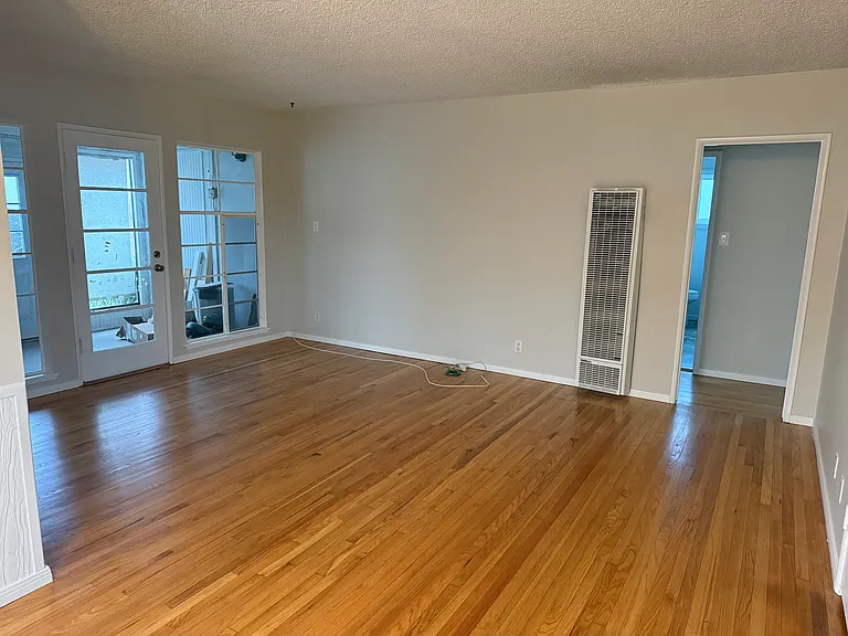 Living room & enclosed patio. Doorway to hall & bedrooms.