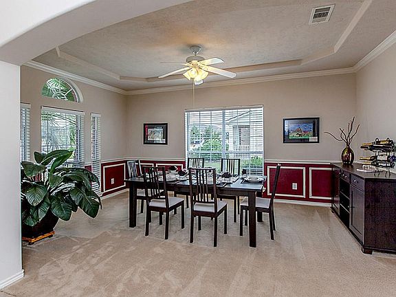 INVITING FORMAL DINING AREA WITH ARCHED WALKWAY, COFFERED CEILING + EXTENSIVE WOOD TRIM ~