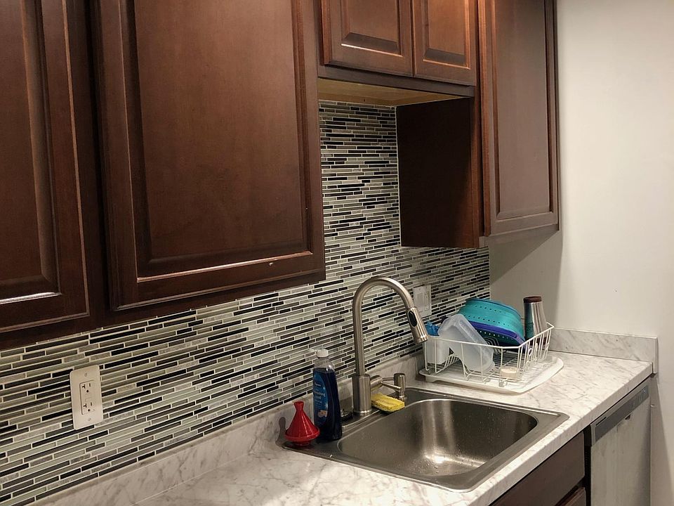 The kitchen includes large cabinets, spacious countertop, and dishwasher