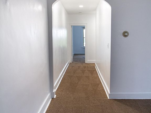 Long, wide hallway leads to two bedrooms and bathroom.