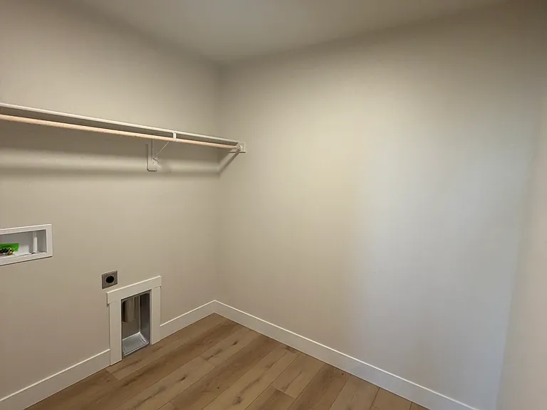 Designed with practicality in mind, the spacious laundry room provides plenty of room for a full-size washer and dryer, storage shelving, and laundry essentials.
