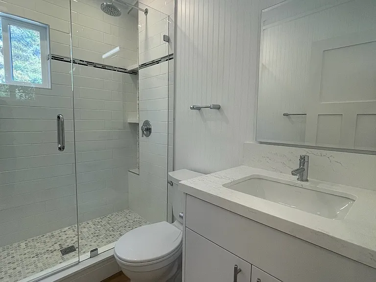 Spacious bathroom with luxurious fixtures and ample lighting.