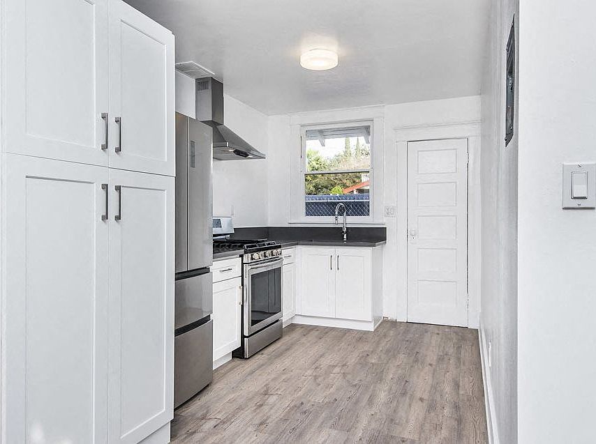 Kitchen with spacious cabinets, gas range, large refridgerator, and back door at 4141 Normal Avenue in Los Angeles, California.