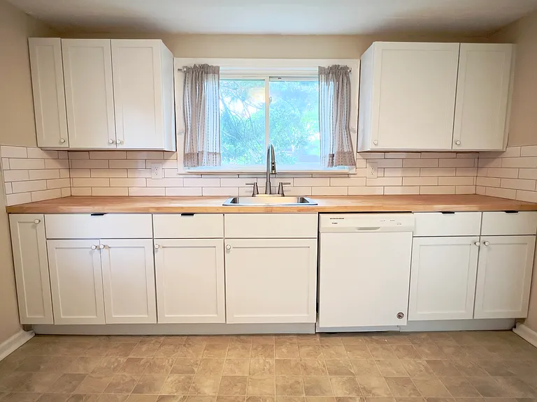 New kitchen with butcher block countertop and dishwasher