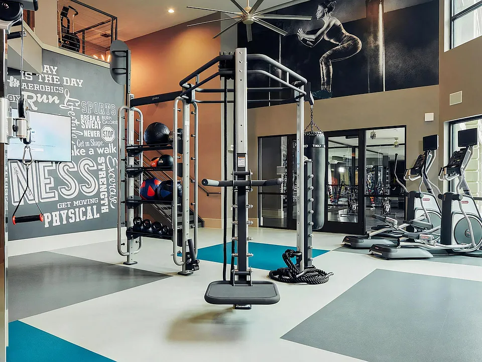 Open Gym Space with Cable Trainer, Punching Bag, and Cardio Machines