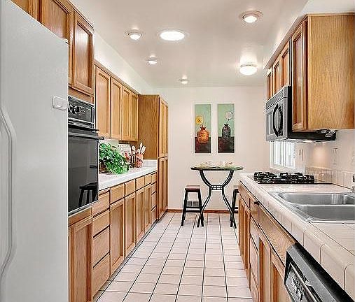 Kitchen with tile floors and counters. Gas range!