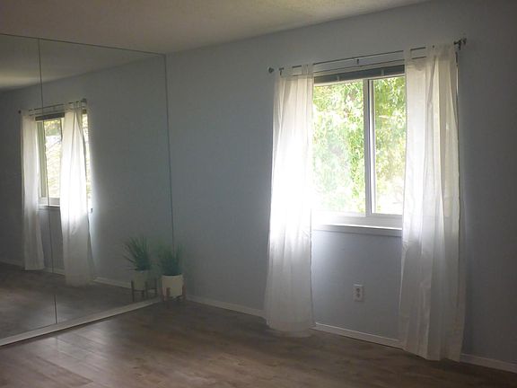 Second and partial view of living room with mirror and window.