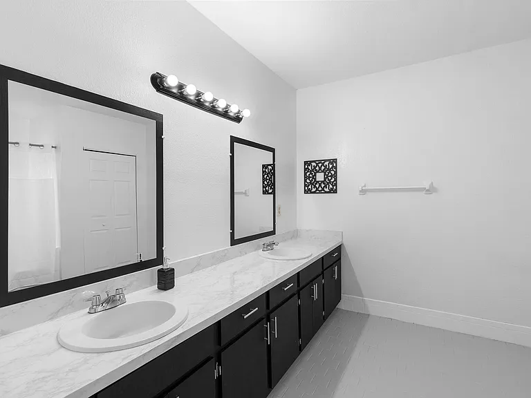Clean double-sink bathroom with mirrors & bright lighting Sanford, FL