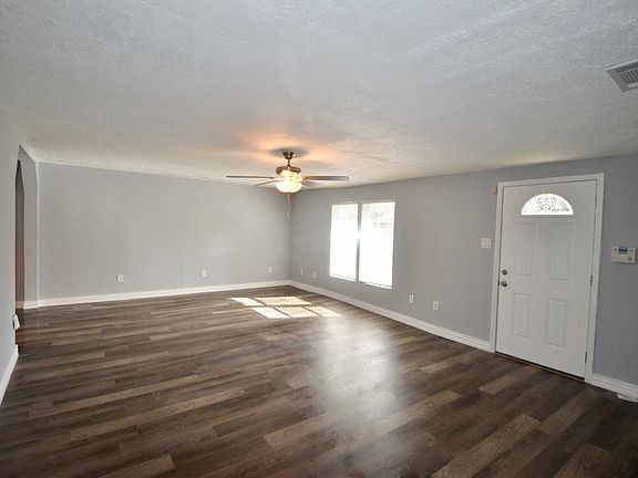 Large living room at front of house features fresh paint and brand new flooring.