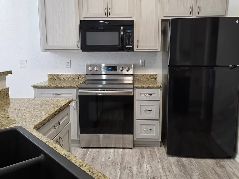 kitchen has electric range, refrigerator with ice maker, microwave, dishwasher
