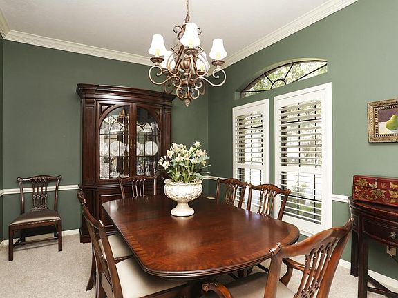 The dining room boasts beautiful transoms and windows outfitted with plantation shutters. The dining