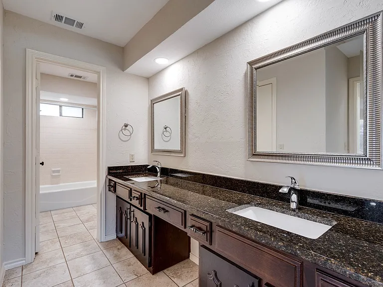 Double sinks in the master bathroom with a separate toilet and shower room.