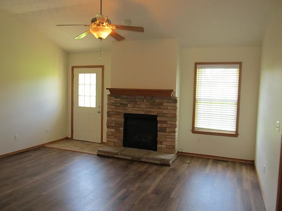 Front room with vinyl plank flooring and gas fireplace. Door to back patio.