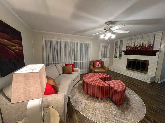 Family room/den, has ample seating w/ultra comfortable curved chenille sectional & round oversized nap sized ottoman or sit alone in the large leather chair. Lamp & end table w/ Wi-Fi smart tv set up 500+ channels. Gas fireplace & back deck access.