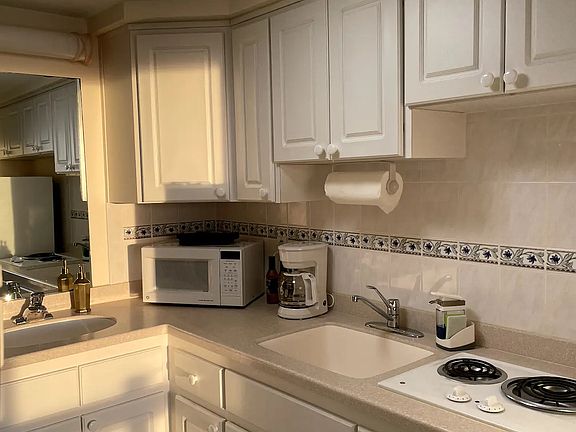 Kitchenette includes full refridgerator and freezer, two sinks, two-burner stove, microwave, coffee maker, utensils, dishware and pots and pans.