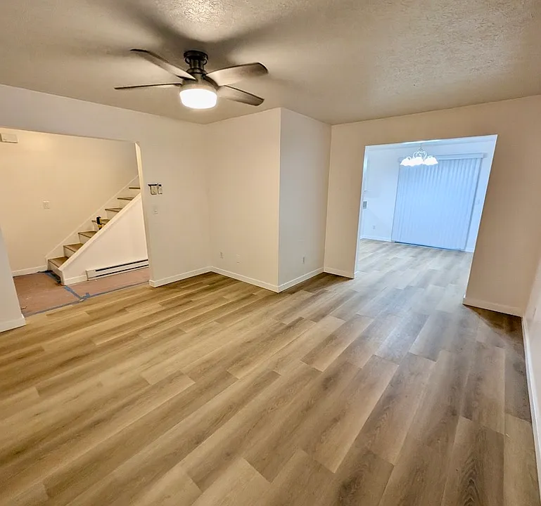 Living Room: Entry to left, stairs to second floor, Dining area and patio slider in the distance