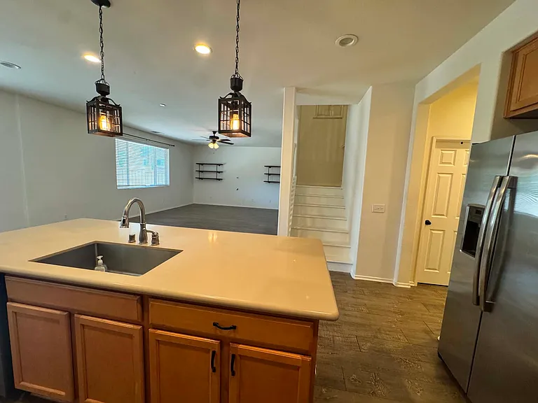 View of the living and dining room area from the beautiful kitchen. And stairs leading to the loft/family room
