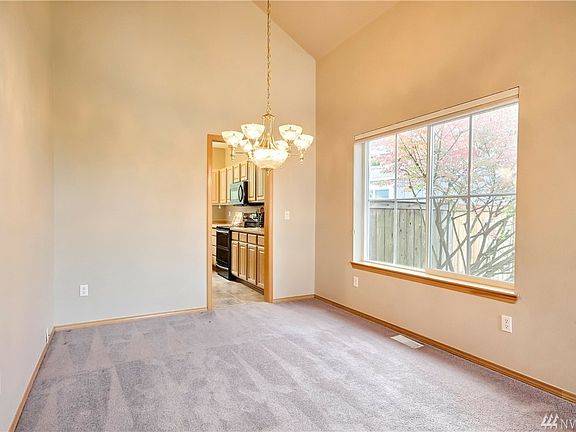 Formal dining room with easy access to kitchen & vaulted ceilings for added spaciousness