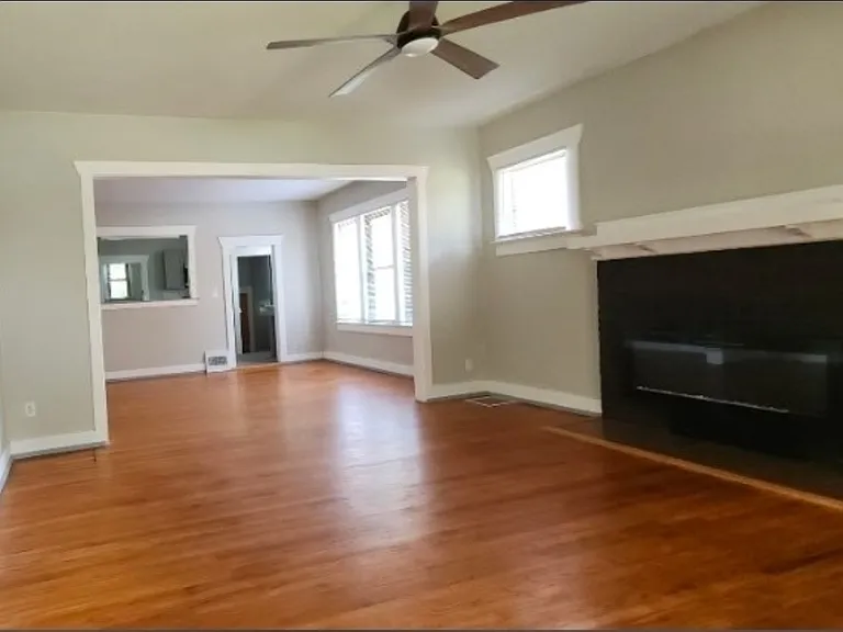 View from entry through living room and formal dining room to the kitchen. Notice the fireplace and beautiful, refinished hardwood floors!