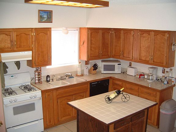 updated kitchen with wood cabinets and tile countertops