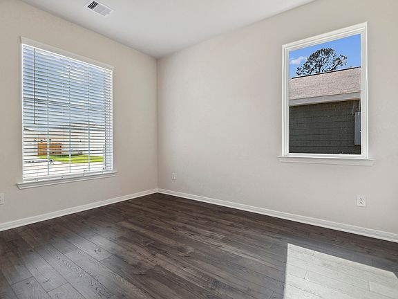 A sperate dining room with two windows.