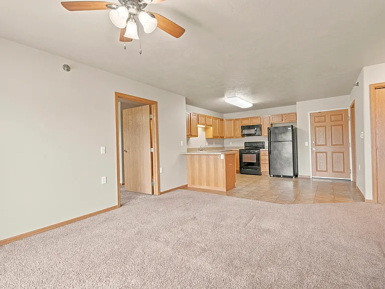 Step into a spacious living area at Northdale Apartments, showcasing an open layout with modern finishes and a well-equipped kitchen. Perfect for comfortable living in a vibrant community. Schedule your tour today!
