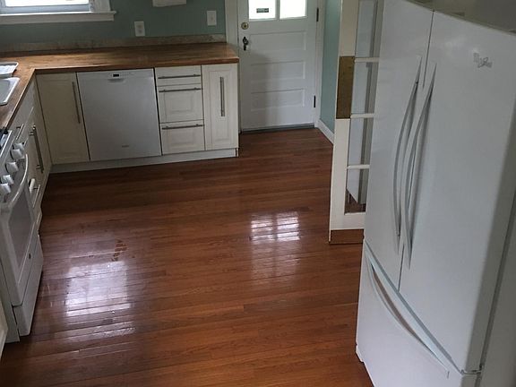 Kitchen with gas stove, above-range microwave, dishwasher, door leading to backyard.