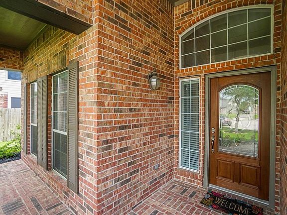 Elegant wood front door and porch at entry.