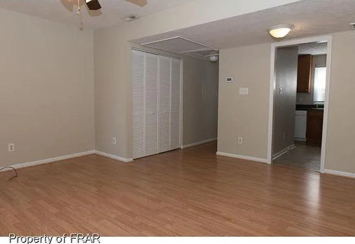 The hidden washer and dryer hookup is behind the bi-fold doors next to the water heater. The area accommodates a full-size set.