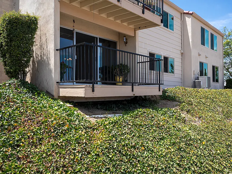 Covered patio overlooking ample greenspace between condominium units.