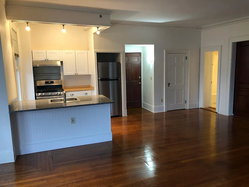 Kitchen area includes entry way and closet pantry. Granite counter has overhang for bar height chairs.