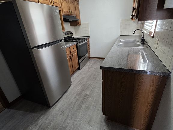 Kitchen with handy pull out base shelves. New stainless steel Fridge and stove, new water/scratch proof flooring, and a new garbage disposal.