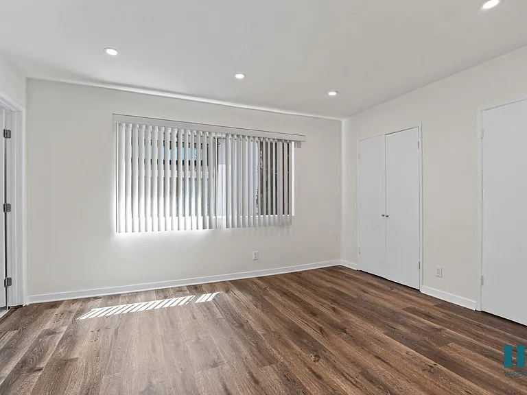 Bedroom with Large-Size Windows, Vinyl Flooring, and Closets