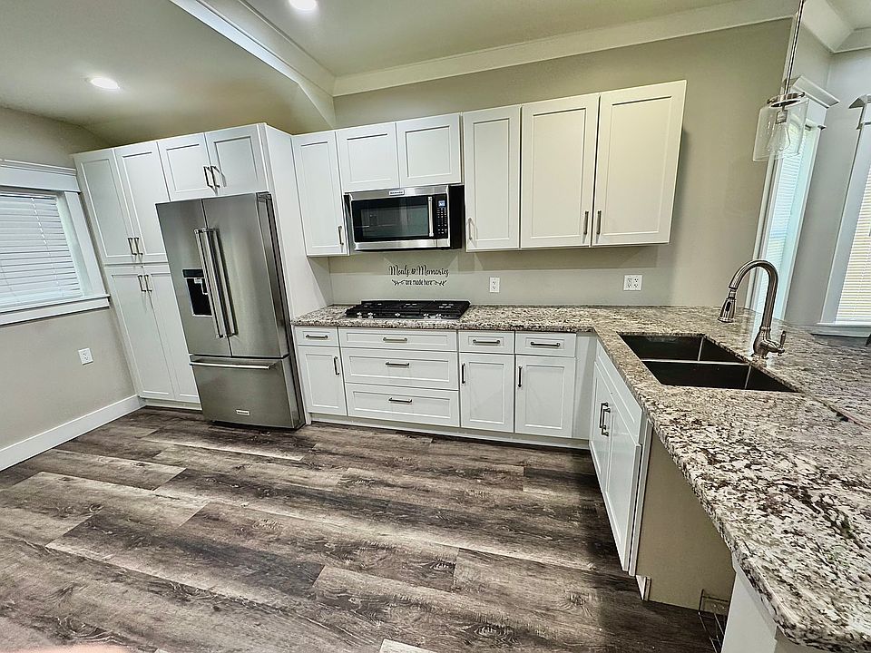 Modern kitchen with brand-new stainless steel appliances, granite countertops, and stylish cabinetry. A new dishwasher will be installed before move-in for added convenience!