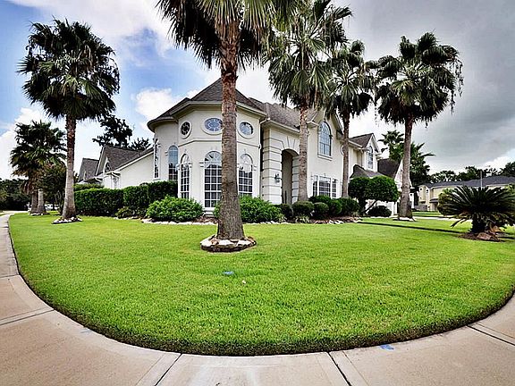 TROPICAL PALM TREES BRING GORGEOUS CURB APPEAL TO THIS HOME IN GREATWOOD SHORES.