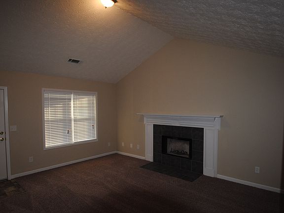Living Room w/ Fireplace and Vaulted Ceilling