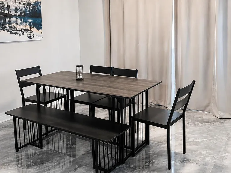 Dedicated dining area with a full-size table and seating, tile flooring, and a window wall with curtains for privacy.