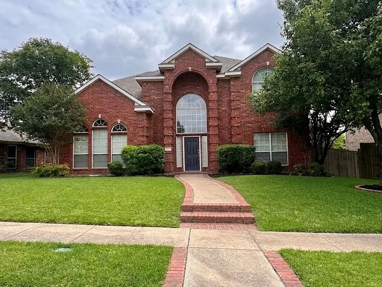 Traditional brick exterior with an arched entry and expansive window