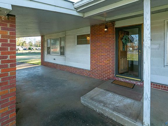 View of the front porch showing the front bedroom windows on the left, then the bathroom window, then the entry & front door, and the beginning of the living room window on the right
