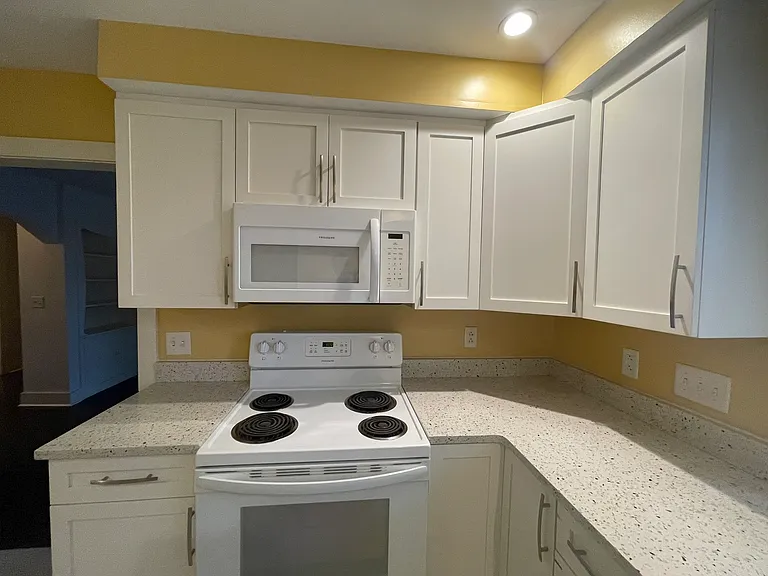Another view of the kitchen. Countertops are recycled glass. Built in microwave.