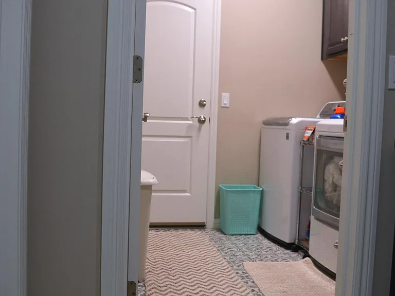 The laundry room is connected to the garage by the door shown in the further end