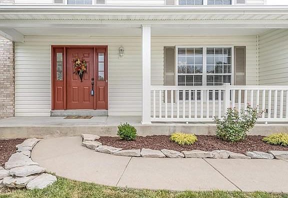 Covered front porch with professional landscaping.
