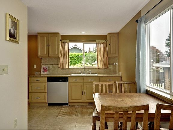 Light and bright kitchen features a tile floor, high end granite, double pane windows, stainless appliances that stay with the home and views from this room too.