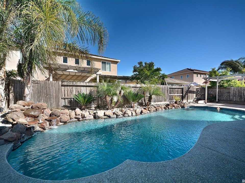 Beautiful large pool with palm trees, rock waterfall and patio.  Perfect for summer entertaining.
