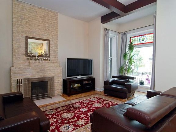 Living Room with fireplace, vintage stained glass, bay windows, tall, vaulted ceiling