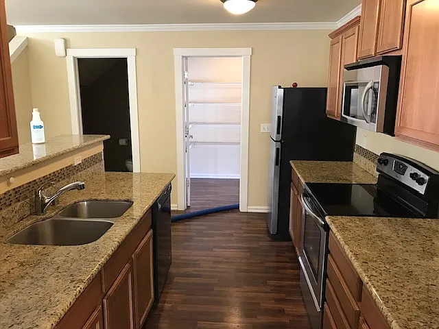 Kitchen with granite counters open to living area , large walk in pantry